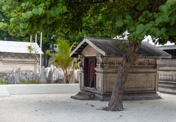 Historic stone structures and ancient graves under a green tree