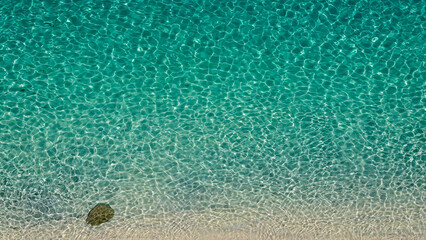 Transparent turquoise water surface gently washing the white sandy beach of Tropea, Calabria, in Southern Italy