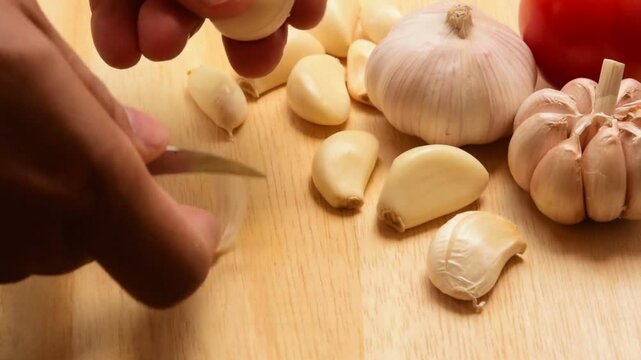 Fresh Garlic Cloves and Bulbs on Wooden Cutting Board