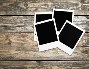 Four blank instant photos scattered on a rustic weathered wooden surface memories concept
