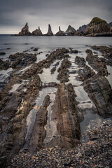 scenic seascape with rising rocks on the beach in long exposure