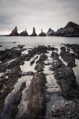 scenic seascape with rising rocks on the beach in long exposure