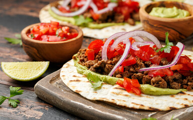Tasty Beef Tacos with guacamole, tomato, onion and sauce. Tortilla Fast Food.