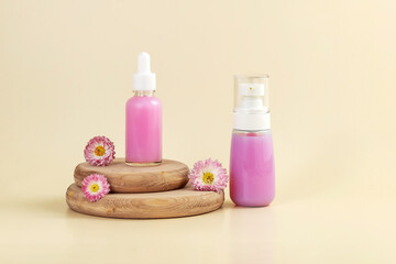 Cosmetics containers and daisy flowers on a beige background.  The concept of skin care using natural cosmetics
