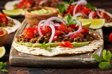 Tasty Beef Tacos with guacamole, tomato, onion and sauce. Tortilla Fast Food.