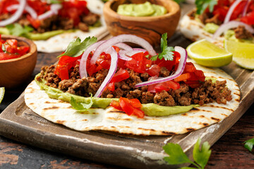 Tasty Beef Tacos with guacamole, tomato, onion and sauce. Tortilla Fast Food.
