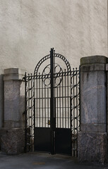 a striking black wrought iron gate with a symmetrical, geometric design dominated by circular...