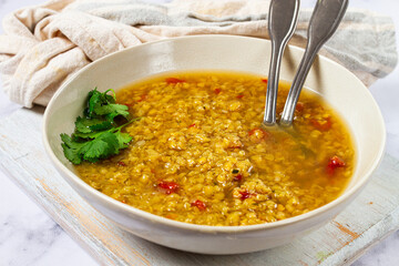 Delicious lentil soup served in a rustic bowl with herbs, perfect for a cozy meal on a chilly evening