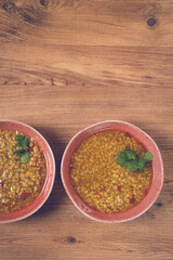 Warm barley stew served in rustic bowls, garnished with fresh herbs, on a wooden table