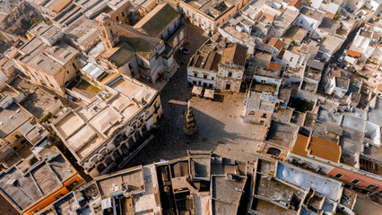 Fototapeta premium Aerial view of the baroque heart of Nardo, Italy, during golden hour. The cathedral and white rooftops glow in warm light, revealing the towns intricate historic layout
