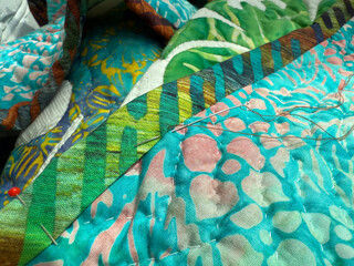 Hand Sewing Binding to the Back of a Quilt. Sewing Hobby Concept. Handmade Mobile Photo, Selective Focus, Harsh Sunlight, Not AI