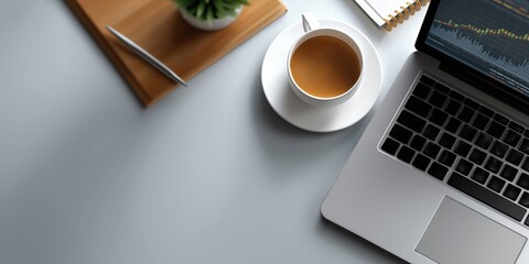 Office workspace with coffee cup and laptop displaying financial graphs