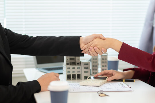 Inside a real estate office a real estate agent is presenting a condominium unit for sale to a client and offering a valuable promotion to entice the client to purchase their own property. copy space