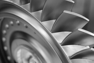 A close up of a turbine blade with many small holes. The blade is silver and has a shiny appearance