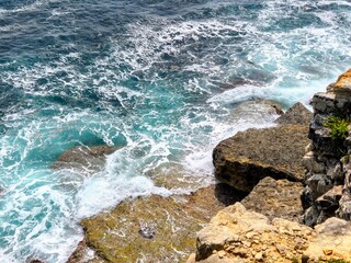 Waves Crashing on Rocky Shoreline – Aerial View of Turquoise Sea Foam and Coastal Texture
