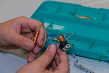 Techniker wickelt Kupferdraht um eine Spule