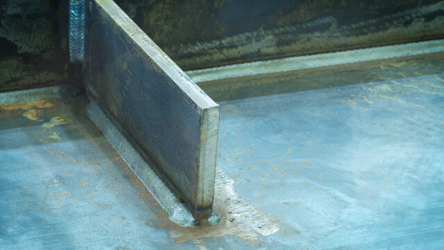 A weld seam attaches a metal part to another metal surface, metal welding industrial reliability and strength concept background