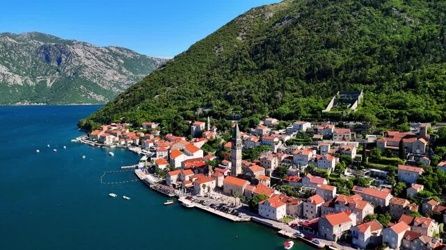 Aerial view of the historic town of Perast, located in the famous Bay of Kotor, on a bright and sunny  day with a blue sky.A drone flies over the picturesque resort town with a rich history.Montenegro