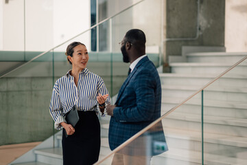 Businesspeople talking on stairs in modern office building