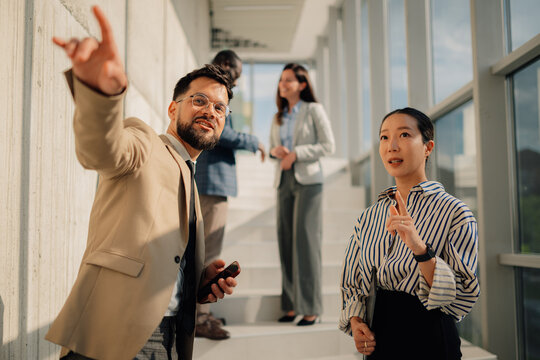 Business team discussing strategy in modern office hallway