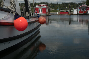 Red round boat fenders hanging of boat docked in Poulsbo marina