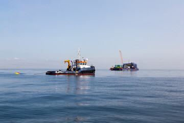 Floating crane and tugboat in the open sea.