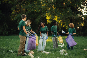 Group of volunteers picking up trash in park