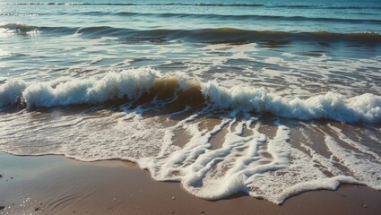 Gentle waves crashing on the sandy shore at the beach.