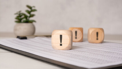 wooden block with exclamation mark on office documents
