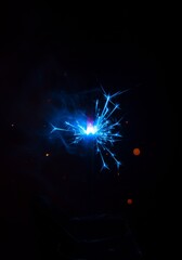 Obraz premium Blue Sparkler Against Black Background
