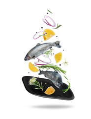 Sea trout with rosemary branches and lemon slices falling on a black clay plate, isolated on white background