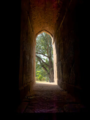 Window arch with stone frame, creating a narrow passage between light and shadow. Historic,