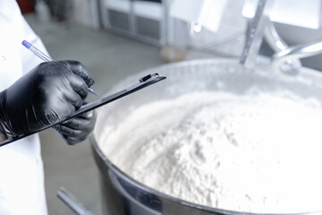 Quality check by worker technologist in dough mixing process at puff pastry production facility