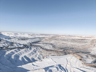 Panorama photo by drone Expansive open pit coal mine landscape snow-covered