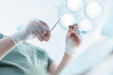 Male veterinarian performing surgery in clinic operating room with surgical tools