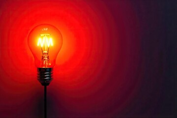 A bright incandescent lightbulb glows intensely against a vibrant red background, creating a striking contrast and symbolic image of ideas, energy, and innovation , intense, heat