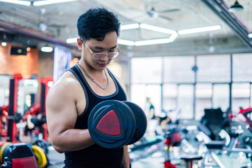 Individual lifting weights in a modern gym setting during daylight hours, focused on physical fitness and strength training activities
