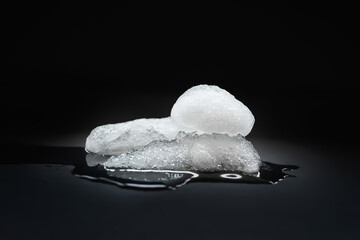 Melting Ice. A piece of melting ice on a dark background. Selective focus