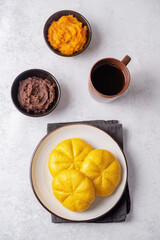 Pumpkin steamed buns with red bean paste filling in a plate