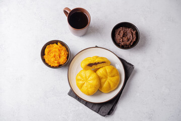 Pumpkin steamed buns with red bean paste filling in a plate