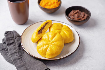 Pumpkin steamed buns with red bean paste filling in a plate