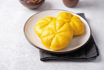 Pumpkin steamed buns with red bean paste filling in a plate