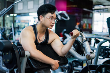 Fitness enthusiast lifts dumbbell while working out in a modern gym during the afternoon, showcasing dedication and strength training