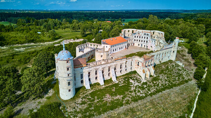 Elevated perspective of the southern bastion and inner arcades of Janowiec Castle under bright...