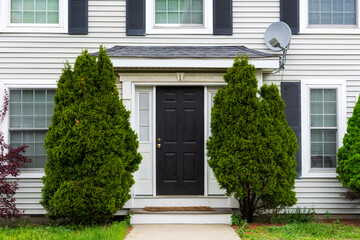 Traditional-style home front door with white trim and small overhead roof in Brighton,...