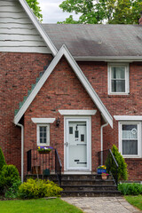 Welcoming entrance of a brick house with potted flowers in Brighton, Massachusetts, USA
