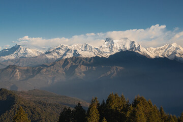 Panoramic sunrise view from Poon Hill in Himalaya mountains, Nepal, showcasing the snow-capped peaks of the Dhaulagiri massif including Tukuche Peak and Gurja Himal.