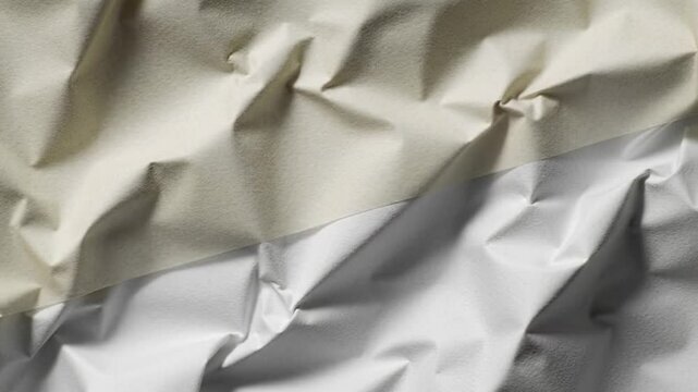 Close up shot showing wrinkled beige and white fabric with visible folds and creases in the material