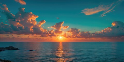 Sunset over the ocean with clouds and horizon, capturing a tranquil seascape scene.