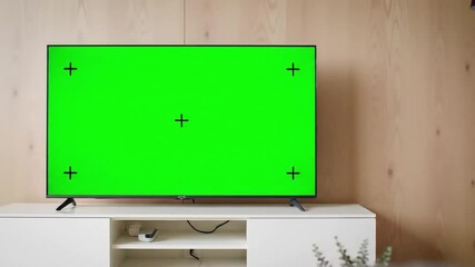 Green Screen Television on White Cabinet in Modern Room